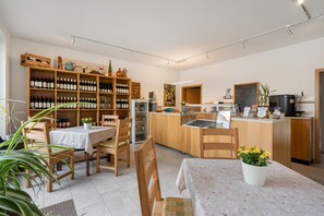 A cozy restaurant with wooden furniture, a bar area, and a wine display.