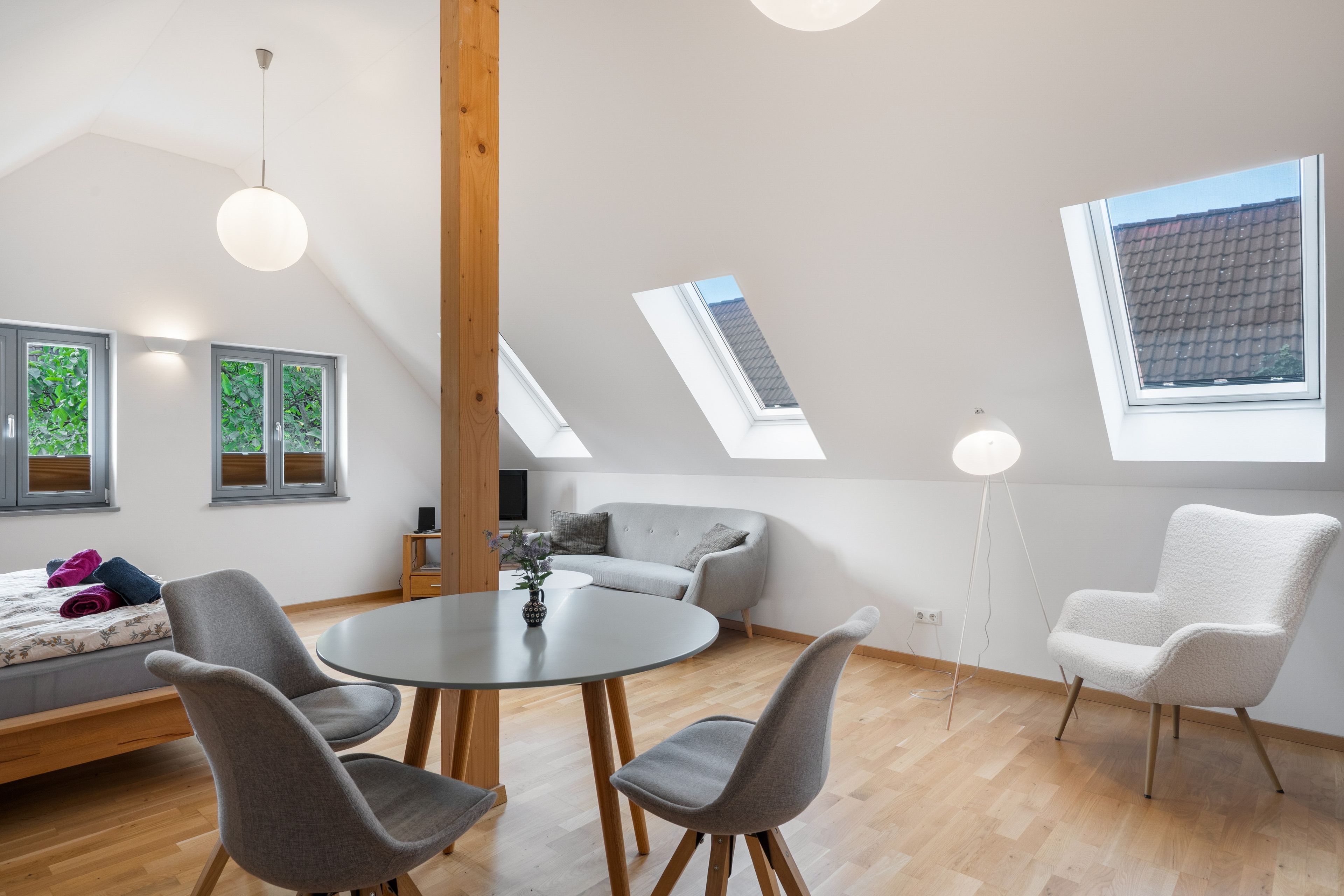 Un intérieur moderne comprenant un coin repas, des sièges et des puits de lumière.