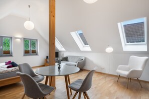 A modern interior with a dining area, seating, and skylights. - Apartment 'Ziegfried#Ziegenhof' (Radebeul)