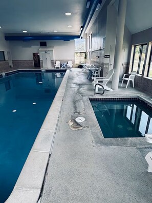 An indoor swimming pool with lounge chairs and a view of the outdoors. - Perfect Peace by the Lake (Keystone)