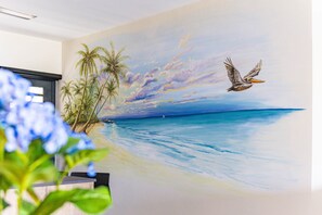 A mural of a beach scene with palm trees and a bird. - Mambo Stay,  luxury apartment with Hot Tub (Willemstad)