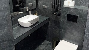 A modern bathroom with a white sink, a toilet, a mirror, and a towel rack. - Apartament z Jacuzzi Kraków GREY Miodowa (Kraków)
