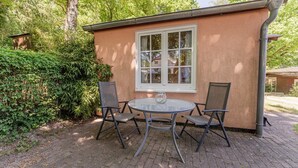 Ein kleines Gebäude mit einem Fenster und zwei Stühlen davor.
