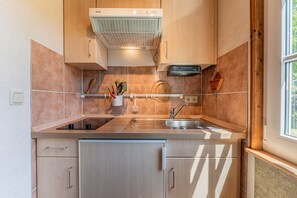 Eine moderne Küche mit Einbauherd, Spüle und Holzschränken.