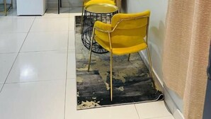 Une pièce comprenant un coin repas, un téléviseur fixé au mur et une petite kitchenette.