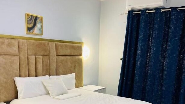 Une chambre d’hôtel équipée d’un lit, d’une table de chevet et d’un climatiseur fixé au mur.