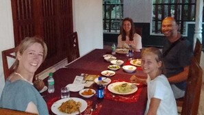 A dining table with plates of food, chairs, and a wooden ceiling. - Rio Lake Hotel Sigiriya (Sigiriya)