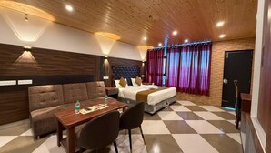 Une chambre d’hôtel avec un sol à carreaux, un canapé, un lit, une table avec des chaises et un plafond en bois.