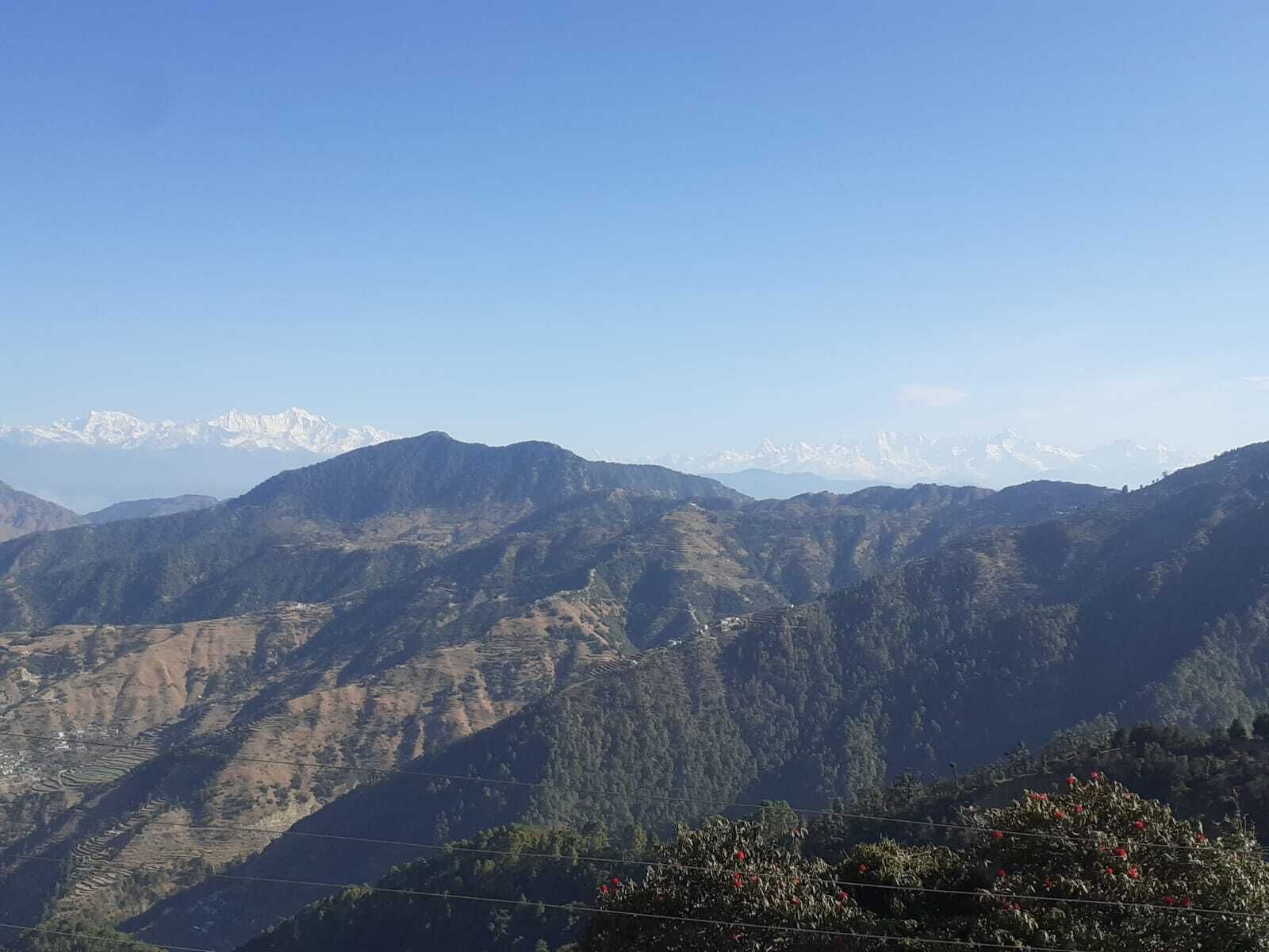 Paisaje montañoso con campos en terrazas y cielo despejado.