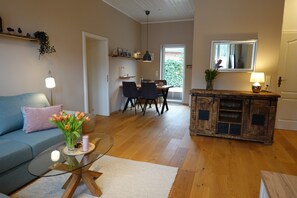 Ein Wohnzimmer mit Sofa, Couchtisch und einem Essbereich mit Stühlen und Tisch.