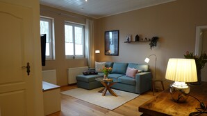Una sala de estar con un sofá, una mesa de centro, una lámpara y una puerta.
