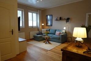 Ein Wohnzimmer mit einer Couch, einem Couchtisch, einer Lampe und einer Tür.