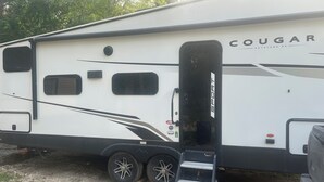 A Cougar Keystone RV with a side door, windows, and a ladder. - 1 bedroom and 3 bunk bed for rent in GIMLI sandy hook (Sandy Hook)