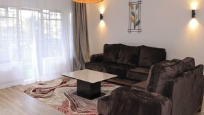 Una sala de estar moderna con un sofá, una mesa de centro y una alfombra estampada.