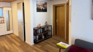 A room with a wooden ceiling, a door, a bookshelf, and a small table with a book. - Old town view (Stockach)
