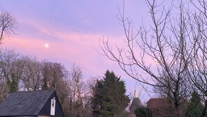 Un quartiere residenziale con una casa, una chiesa e cielo sereno.