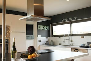Eine moderne Küche mit Einbauofen, großem Fenster und einem Schild mit der Aufschrift 'KITCHEN'.