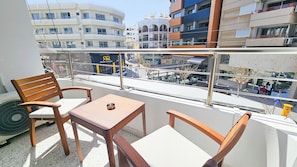 A balcony with wooden furniture, a table, and a view of the cityscape. - The Colors of Larnaca (Larnaca)