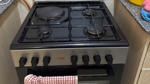 A kitchen with a gas stove, oven, and a stainless steel range hood. - Bright 2-bedroom apartment with AC in serene Nairobi (Nairobi)