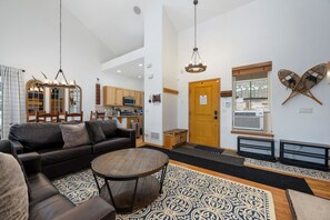 A modern living room with a sofa, coffee table, and patterned rug.