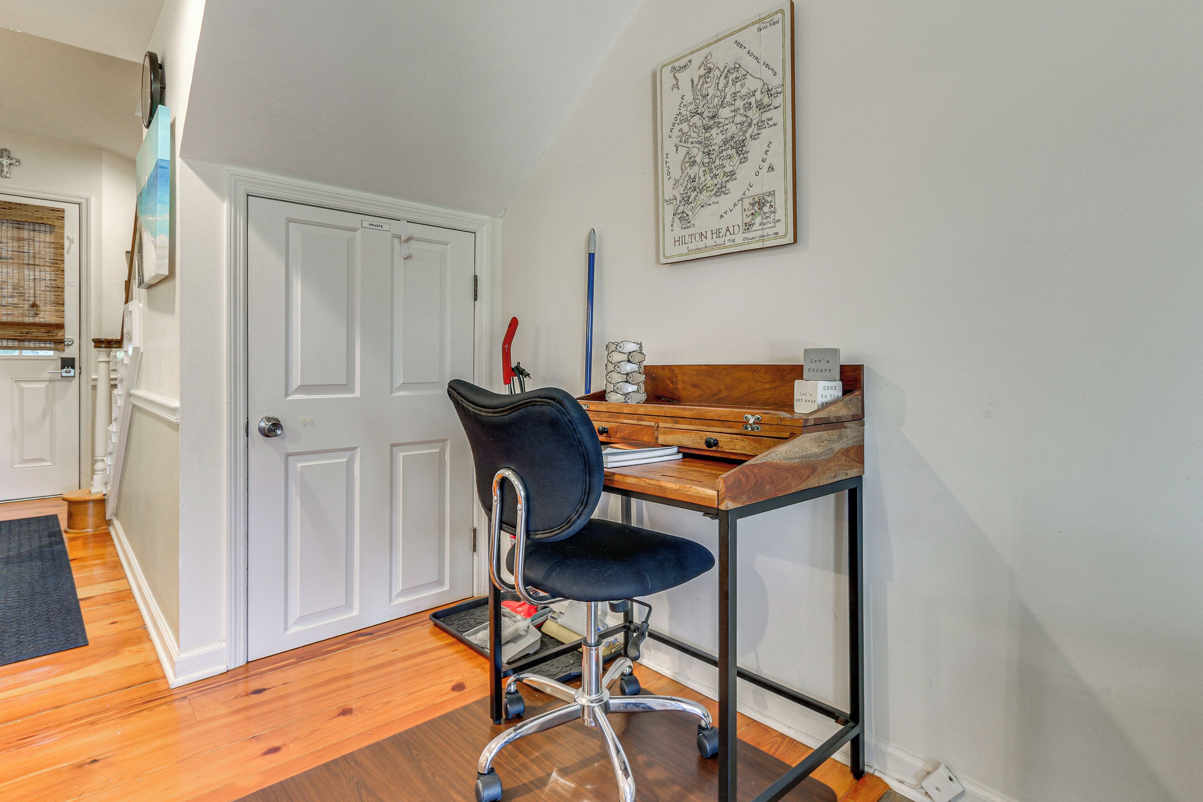 Una habitación con escritorio, silla y un mapa en la pared.