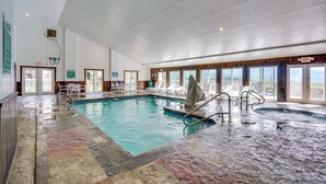 An indoor swimming pool with a view of the ocean, a hot tub, and a seating area with tables and chairs. - Whispering Woods: Smoky Mountain Resort Escape (Gatlinburg)