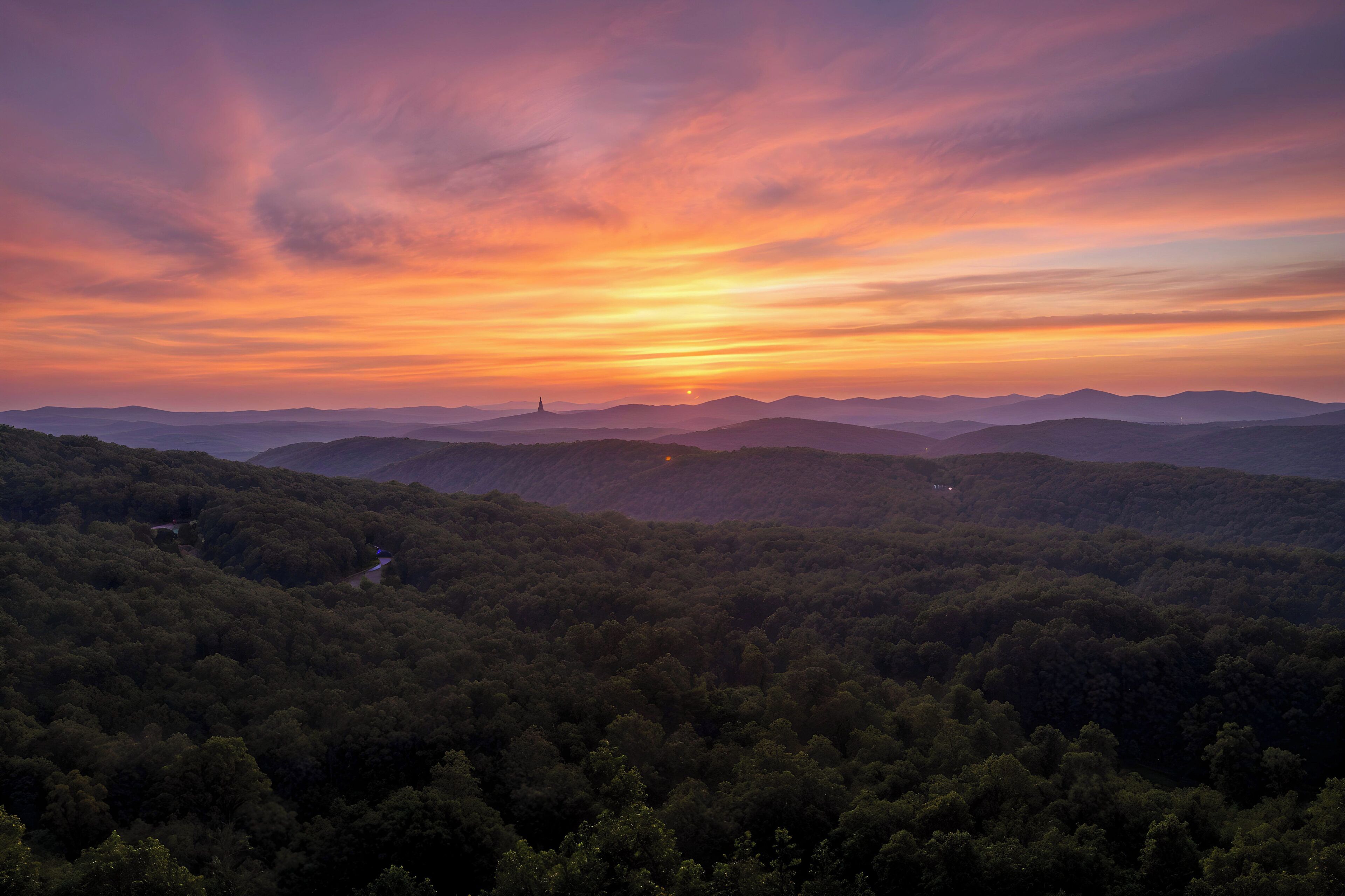 A mountainous landscape with a sunset.