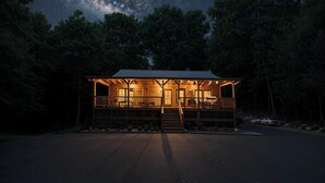 Une cabane dotée d’une véranda, d’un escalier et offrant une vue sur le ciel nocturne.