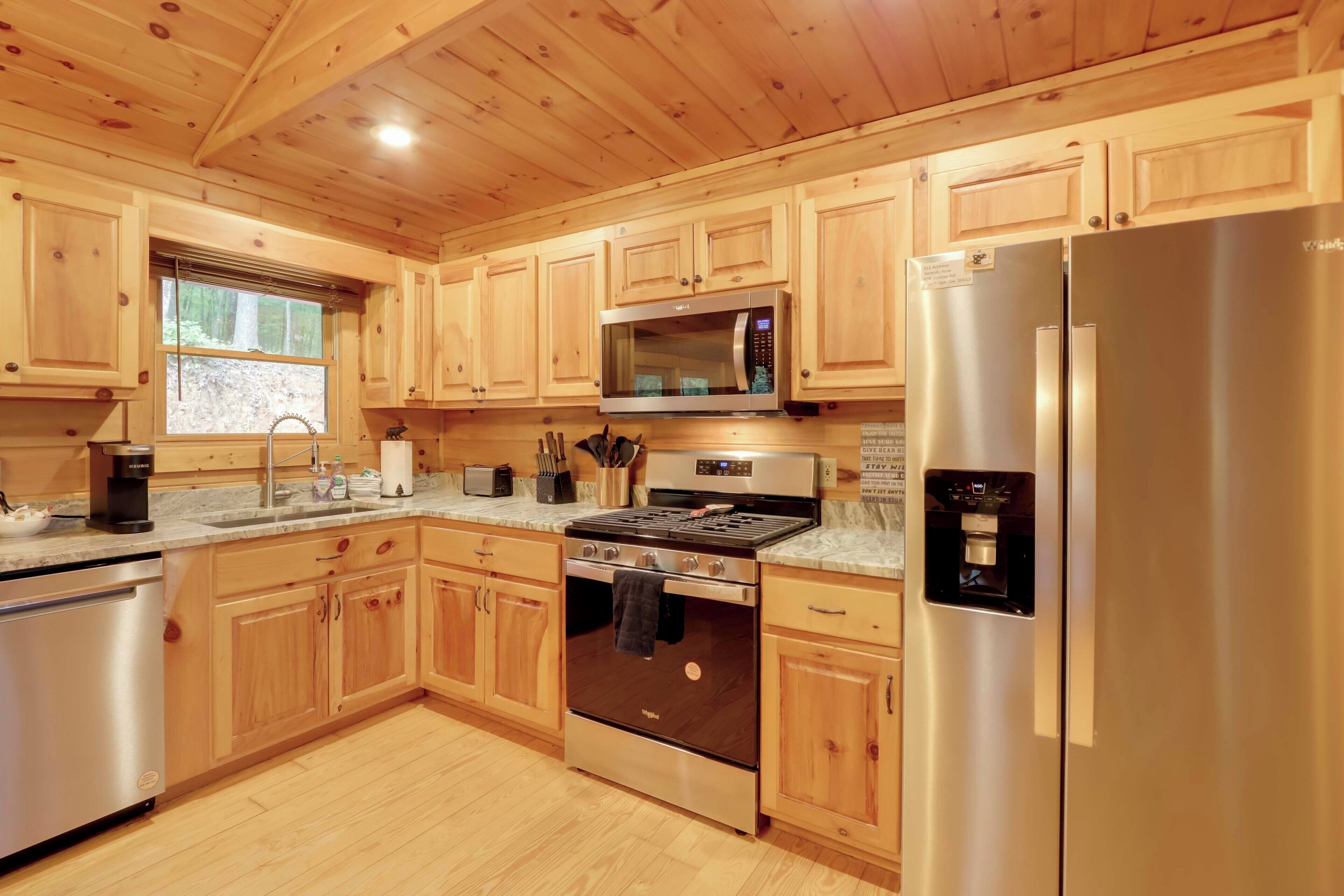 A modern kitchen with wooden cabinets, stainless steel appliances, and a granite countertop.