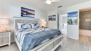 A bedroom with a bed, nightstands, a ceiling fan, and artwork on the walls. - Walk to Ocean! Fernandina Beach 3-unit Getaway (Fernandina Beach)