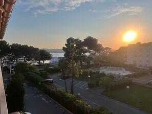 Blick auf eine Marina mit Booten, einem Parkplatz und einem Gebäude mit Balkonen.