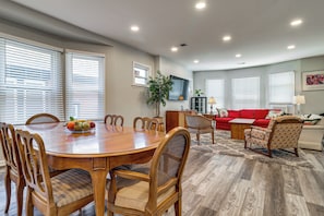 A dining area with a wooden table and chairs, a red sofa, and a plant. - Under 1 Mi to Med Center & Midtown: Detroit Apt (Detroit)