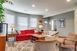 A living room with a red sofa, a patterned armchair, a wooden coffee table, and a lamp. - Under 1 Mi to Med Center & Midtown: Detroit Apt (Detroit)