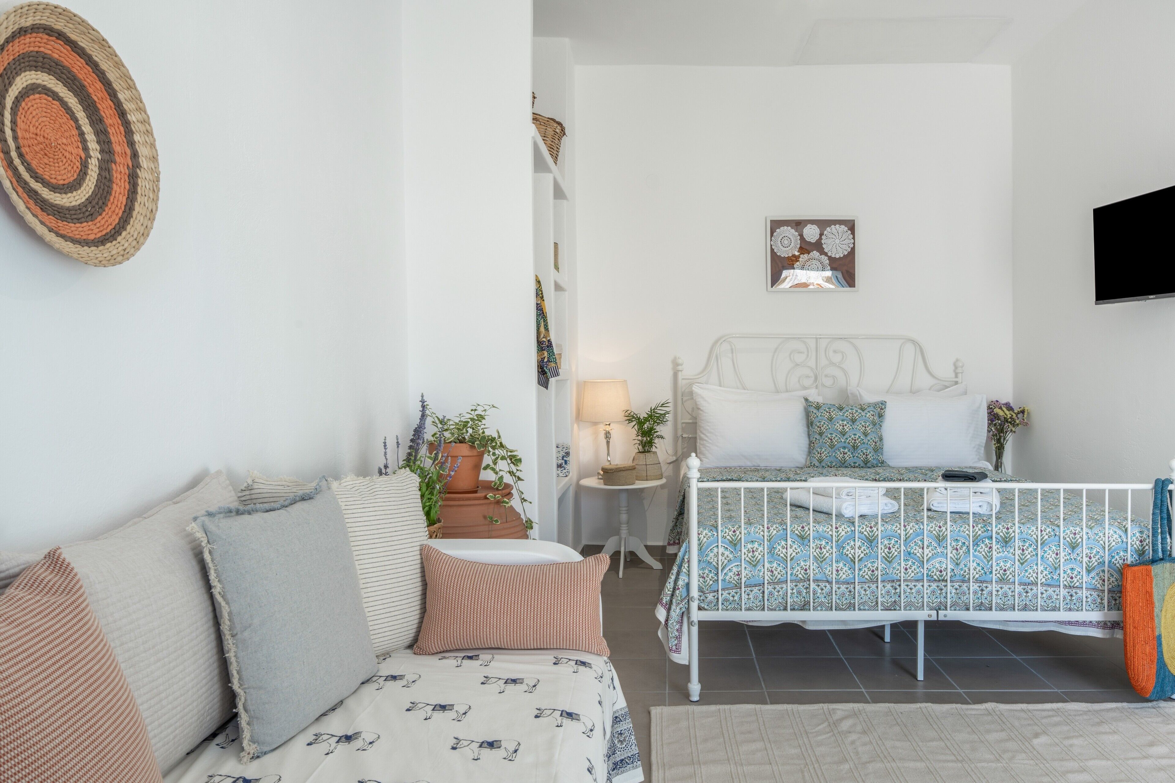 Une chambre à coucher comprenant un lit, des tables de chevet, un téléviseur et une étagère fixée au mur.