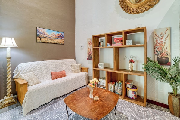 A living room with a sofa, coffee table, wooden bookshelf, and decorative items. - Walk to Clear Lake: 2-unit Church Combo Stay! (Lakeport)
