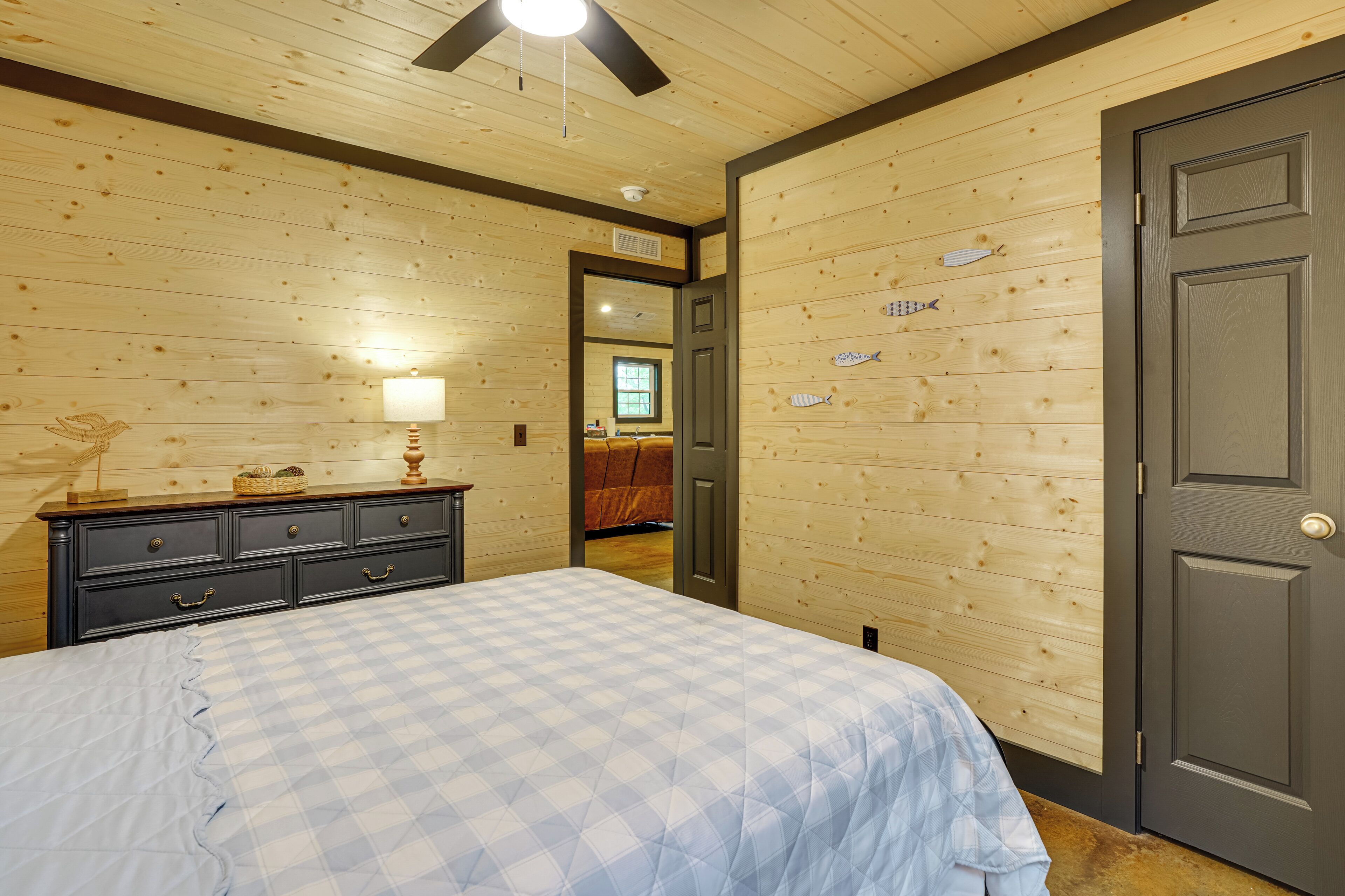 Camera da letto con un letto, una cassettiera e pareti in legno.
