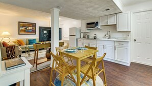 A modern kitchen with white cabinets, a microwave, and a dining area with a wooden table and chairs. - 4 Mi to Lake Bernard Frank! Bright Unit w/ Patio (Rockville)
