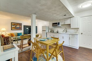 A modern kitchen with white cabinets, a microwave, and a dining area with a wooden table and chairs. - 4 Mi to Lake Bernard Frank! Bright Unit w/ Patio (Rockville)
