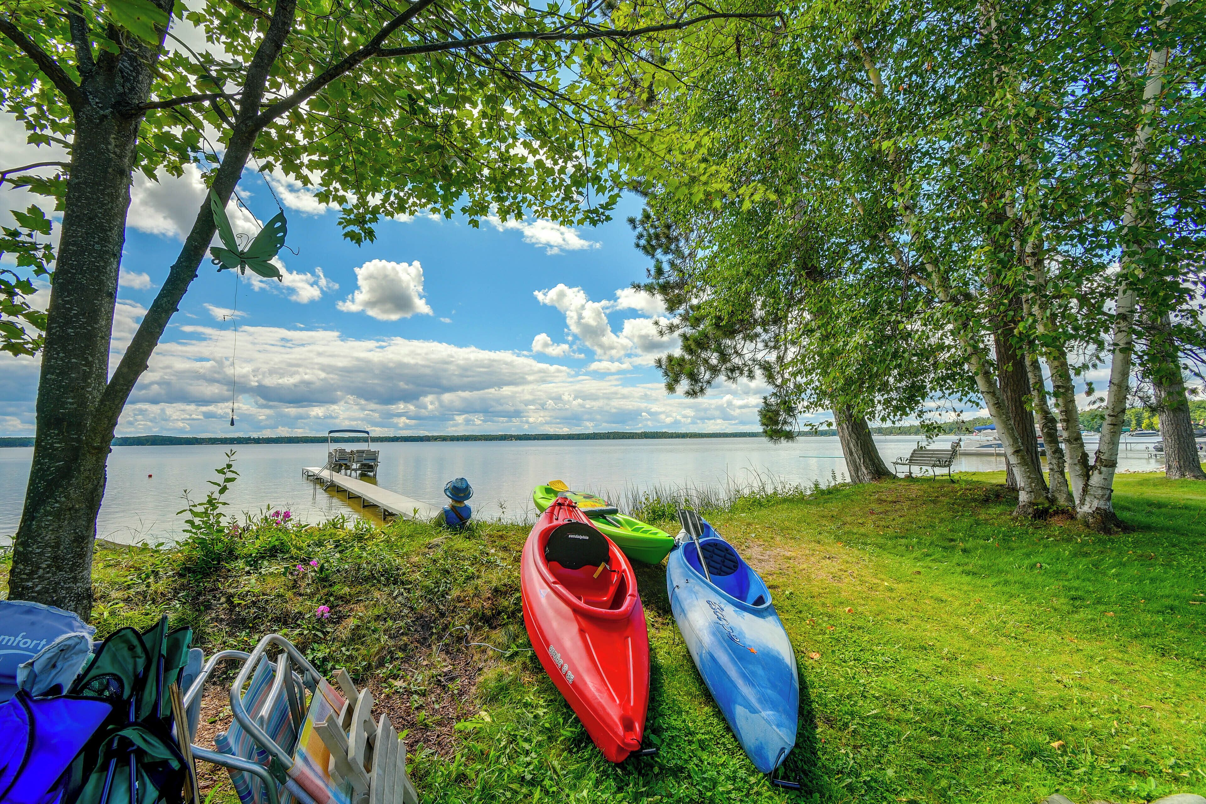 A lakeside setting with kayaks and a bench.