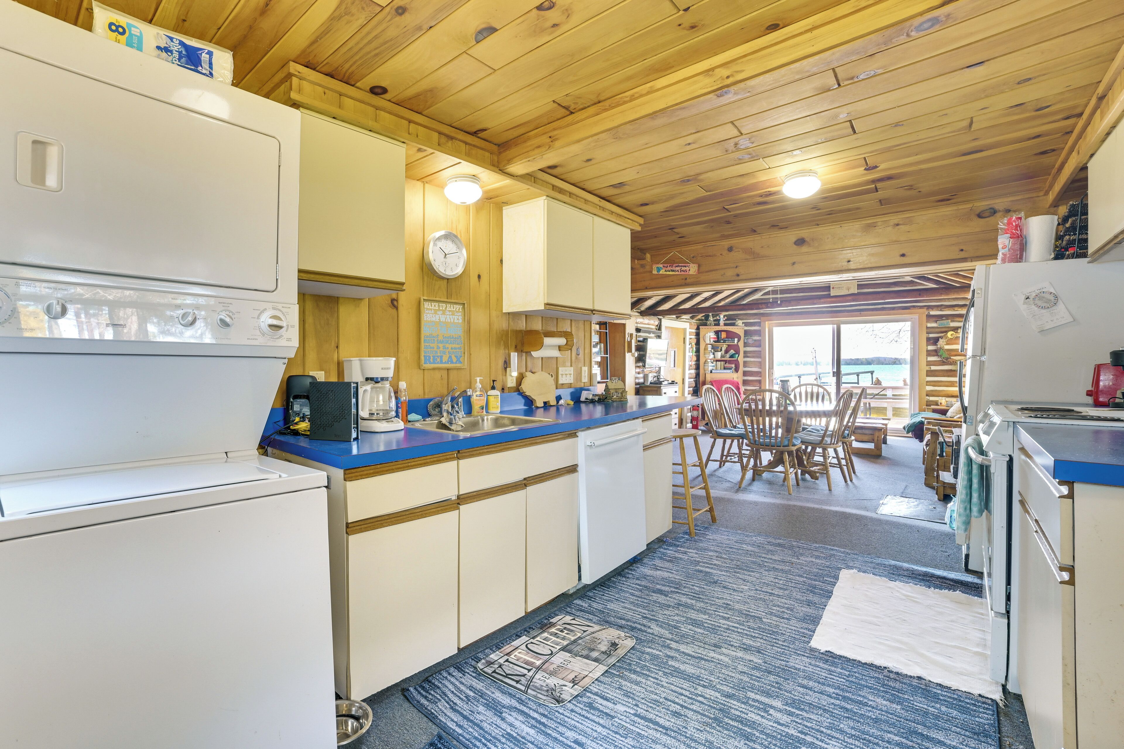 Een keuken met houten kastjes, een blauw aanrecht en een koelkast.