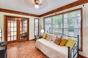 A bedroom with a bed, wooden floor, large windows, and a ceiling fan. - Walkable Location! Peaceful Toccoa Escape w/ Yard (Toccoa)