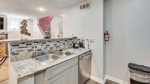 A kitchen with a granite countertop, stainless steel sink, and a dishwasher. - 3BR Townhome Near Downtown Decatur (Decatur)