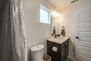Ein Badezimmer mit Toilette, Waschbecken, Spiegel und Handtuchhalter.