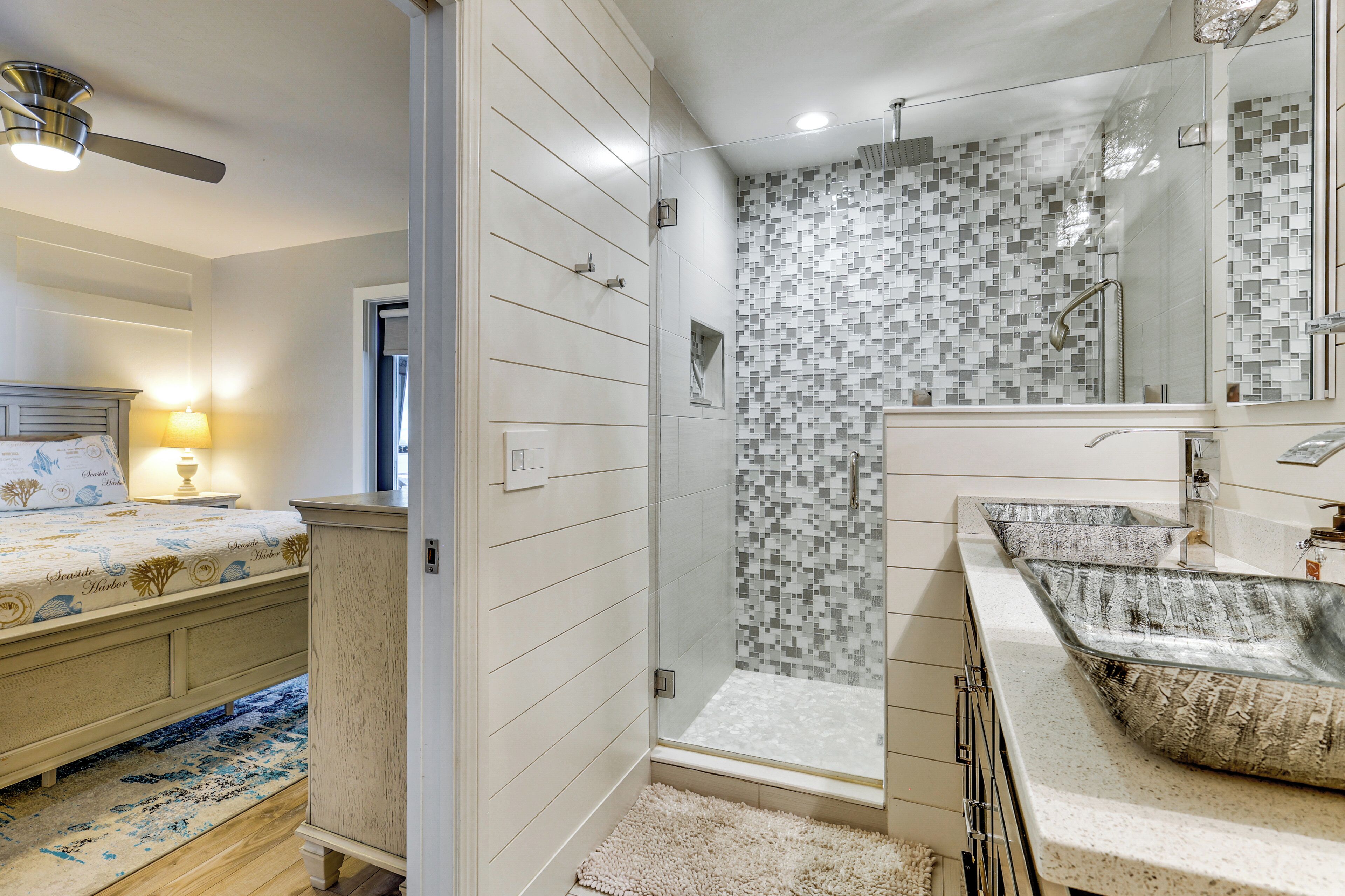 Ein modernes Badezimmer mit Dusche, großem Spiegel und Waschtisch.
