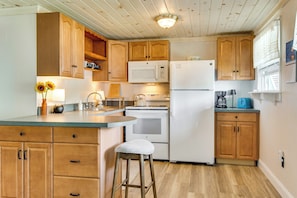 A kitchen with wooden cabinets, a white refrigerator, a microwave, and a stove. - Walk to Wells Beach! Family-friendly Gem w/ Patio (Wells)