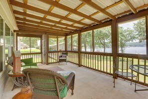 A covered outdoor area with a wooden ceiling, a table, chairs, and a view of a lake. - Lake Ridge Cove, Logan Martin Lake Family Retreat! (Talladega)