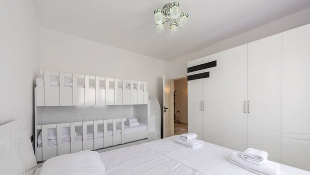 Ein modernes Hotelzimmer mit einem großen Bett, einem weißen Wandschrank und einem durchgegangenen Badezimmer.