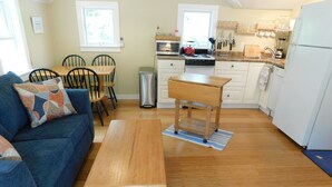 Une cuisine compacte avec un coin repas, un canapé et une petite table.