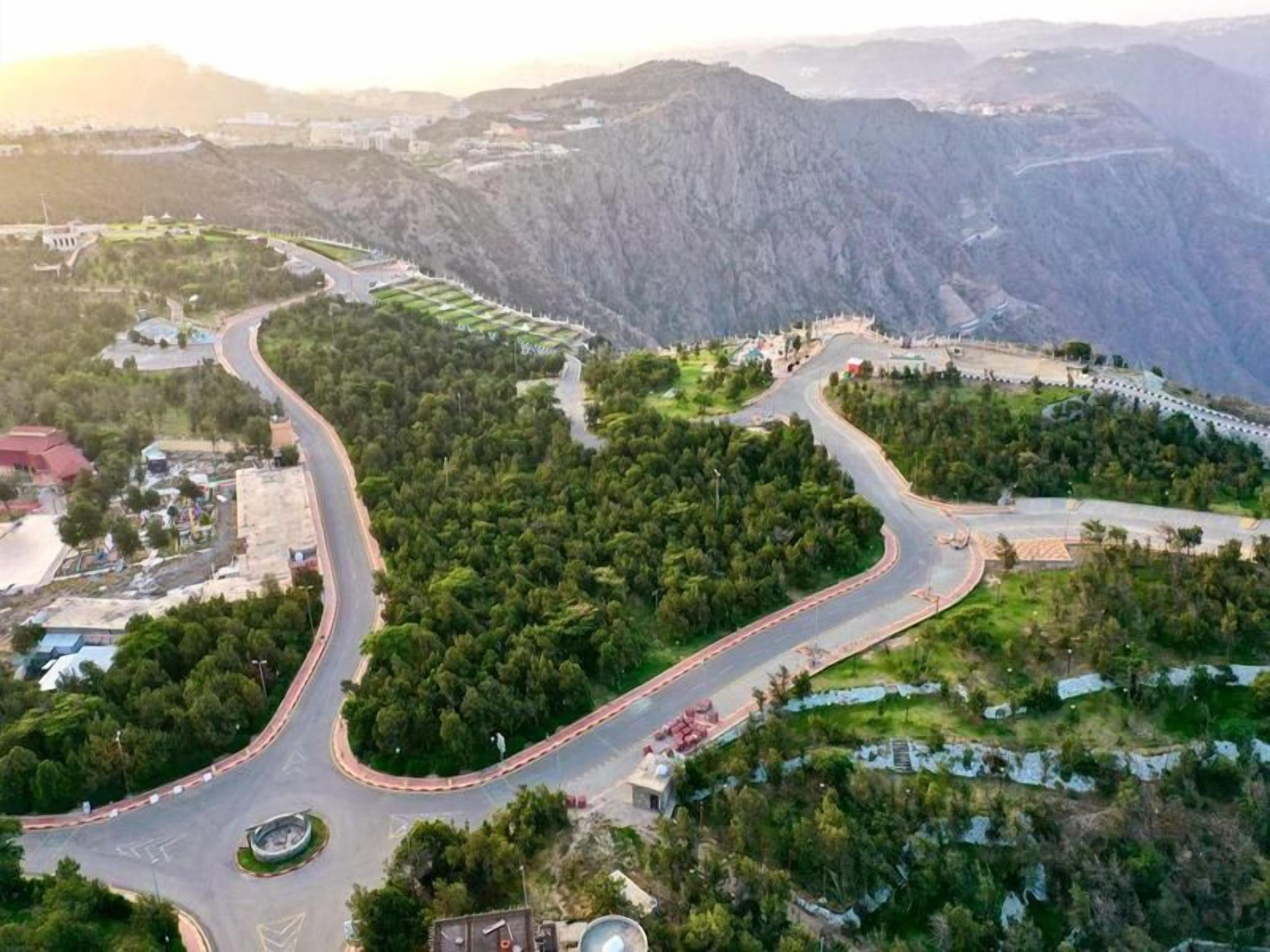 Un camí sinuós a través d'una zona de muntanya amb vegetació als costats.