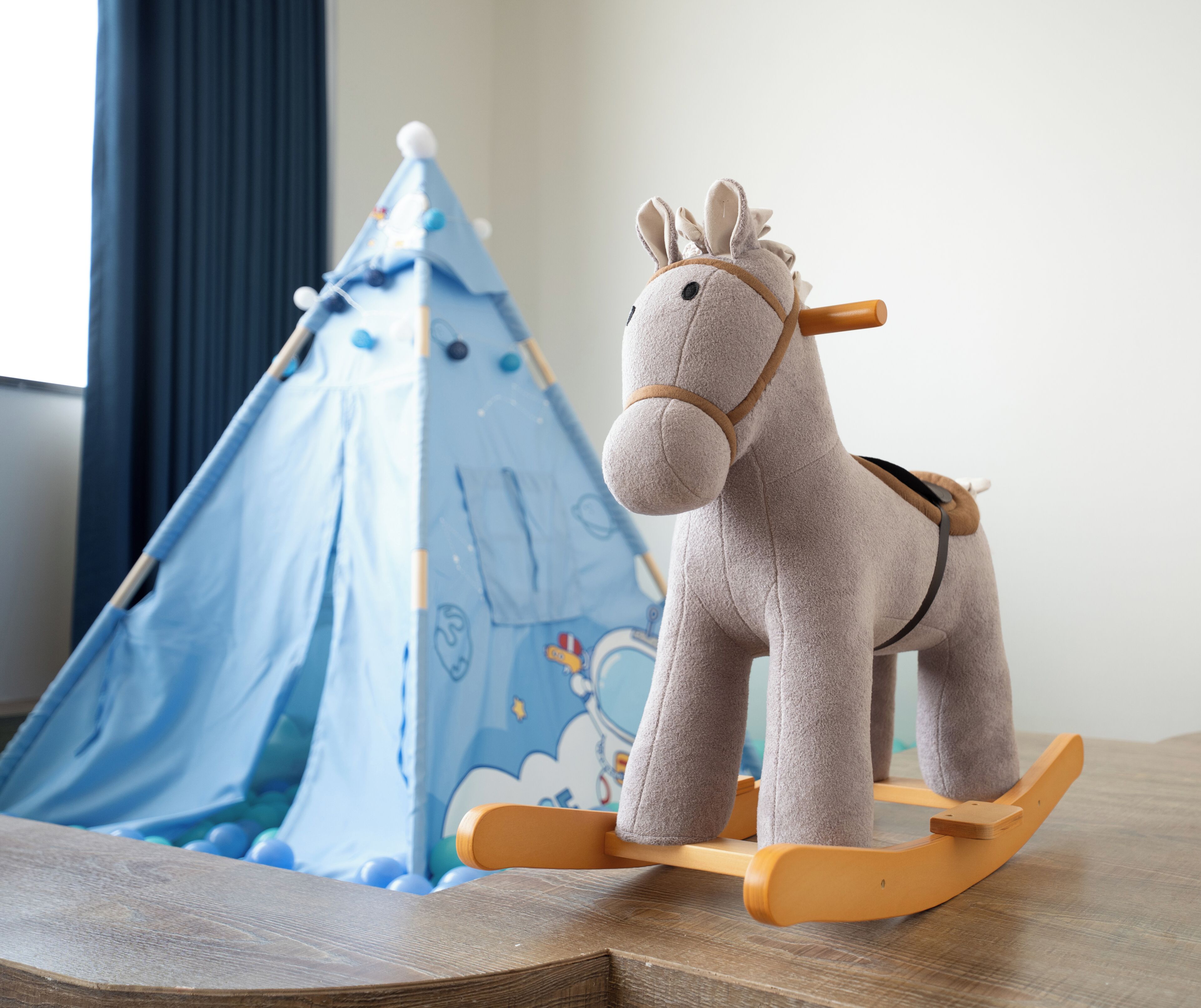 A rocking horse and a blue play tent.